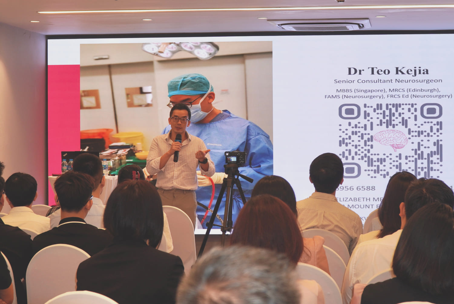 A speaker presenting at a healthcare seminar, with an audience attentively listening in a well-lit room.